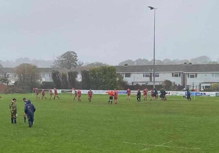 The referee studies the pitch at Crickmarren - and the game goes ahead