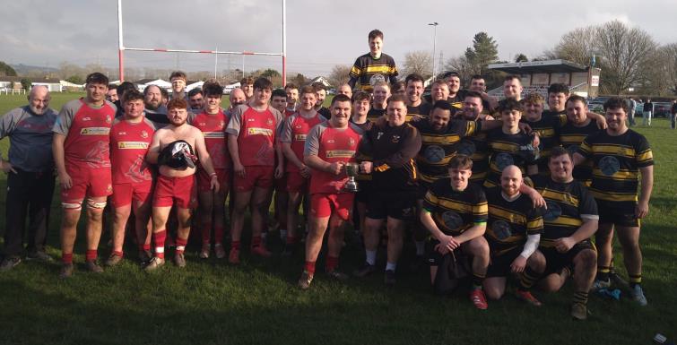Dan Davies receives the Palmer Cup  with both teams around him.