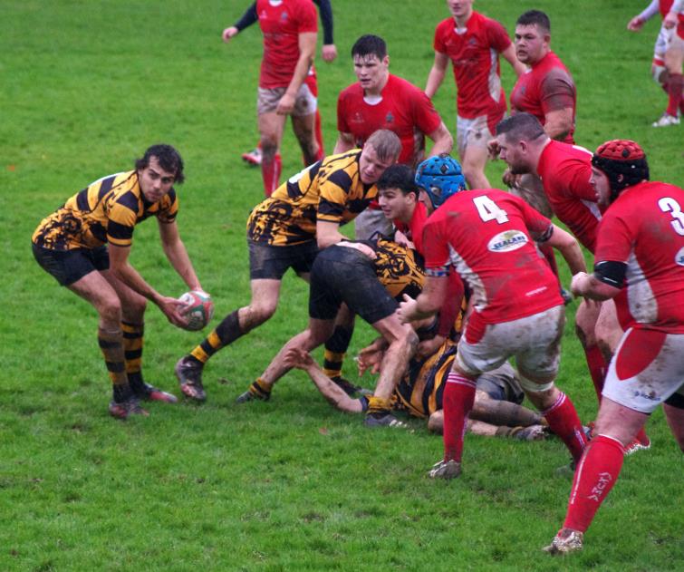 Llangwm scrum half Rhys Mason gets the ball out wide