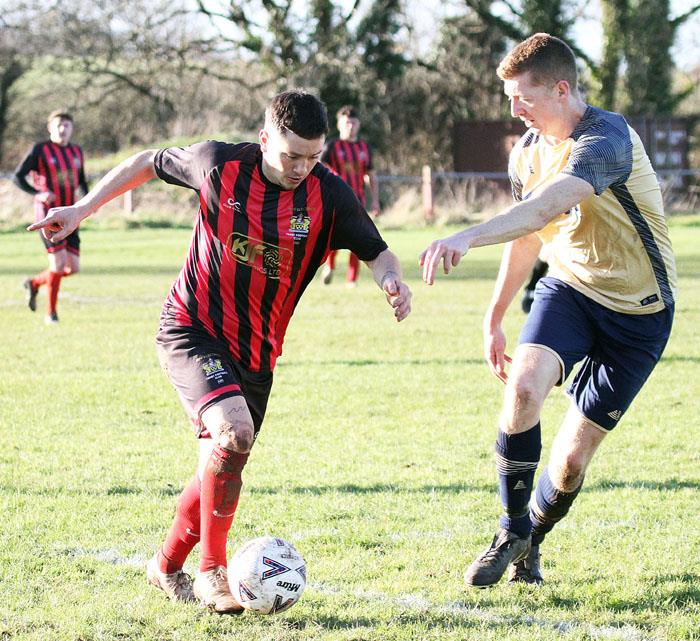 Scott Ferney (who scored from the spot for Tenby) takes on Matthew Griffiths