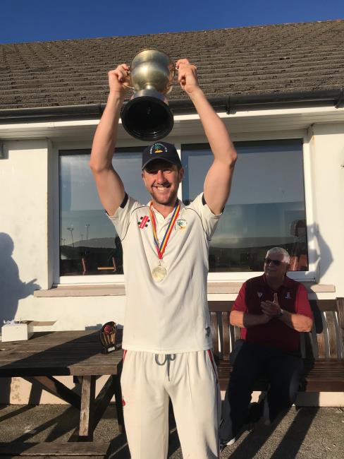 Richard Cope raises the trophy aloft